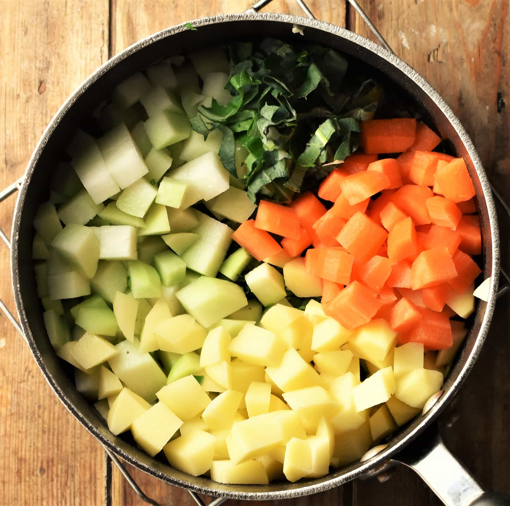 Peeled cubed vegetables in pot.