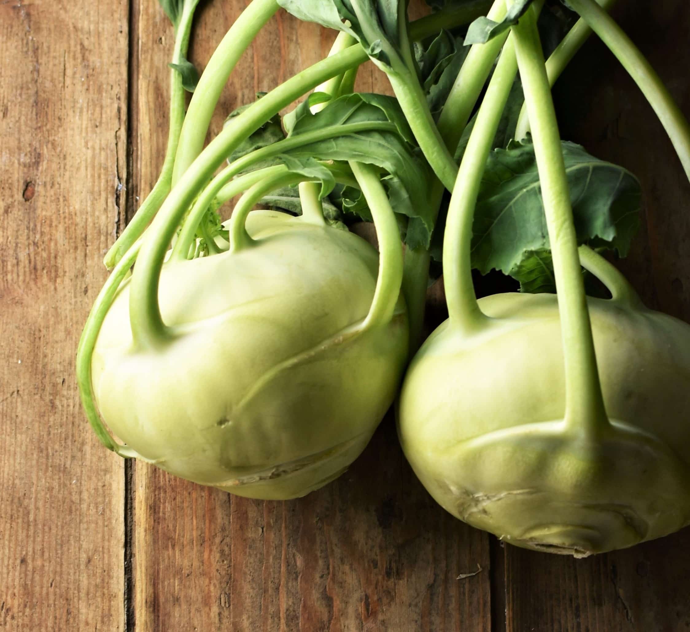 2 kohlrabi bulbs with stems and leaves.