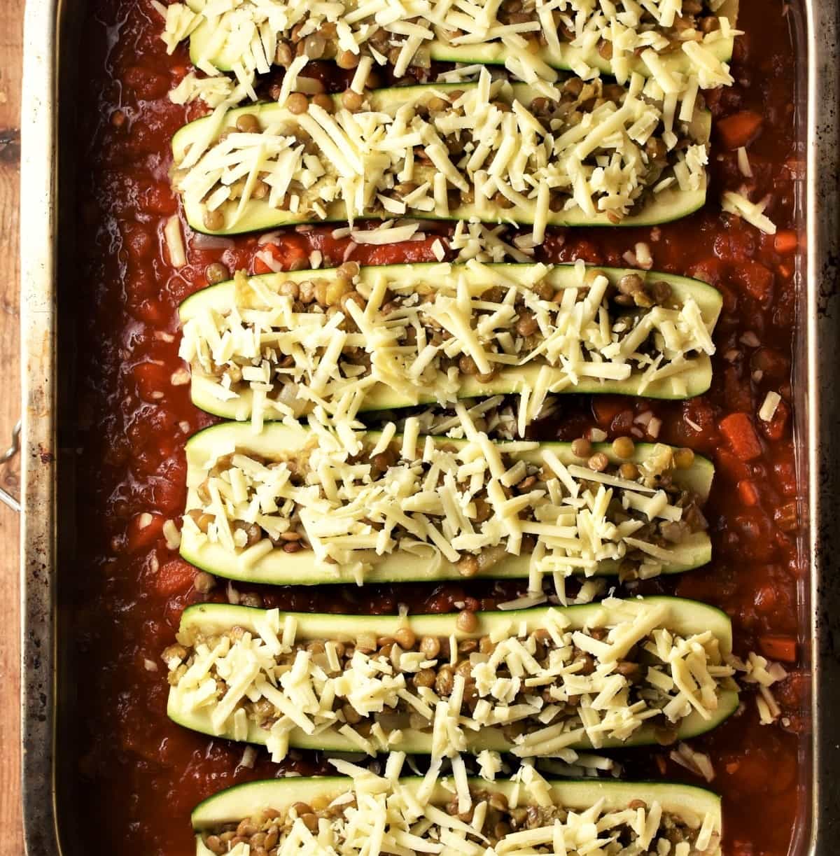 Unbaked stuffed zucchini in tomato sauce.