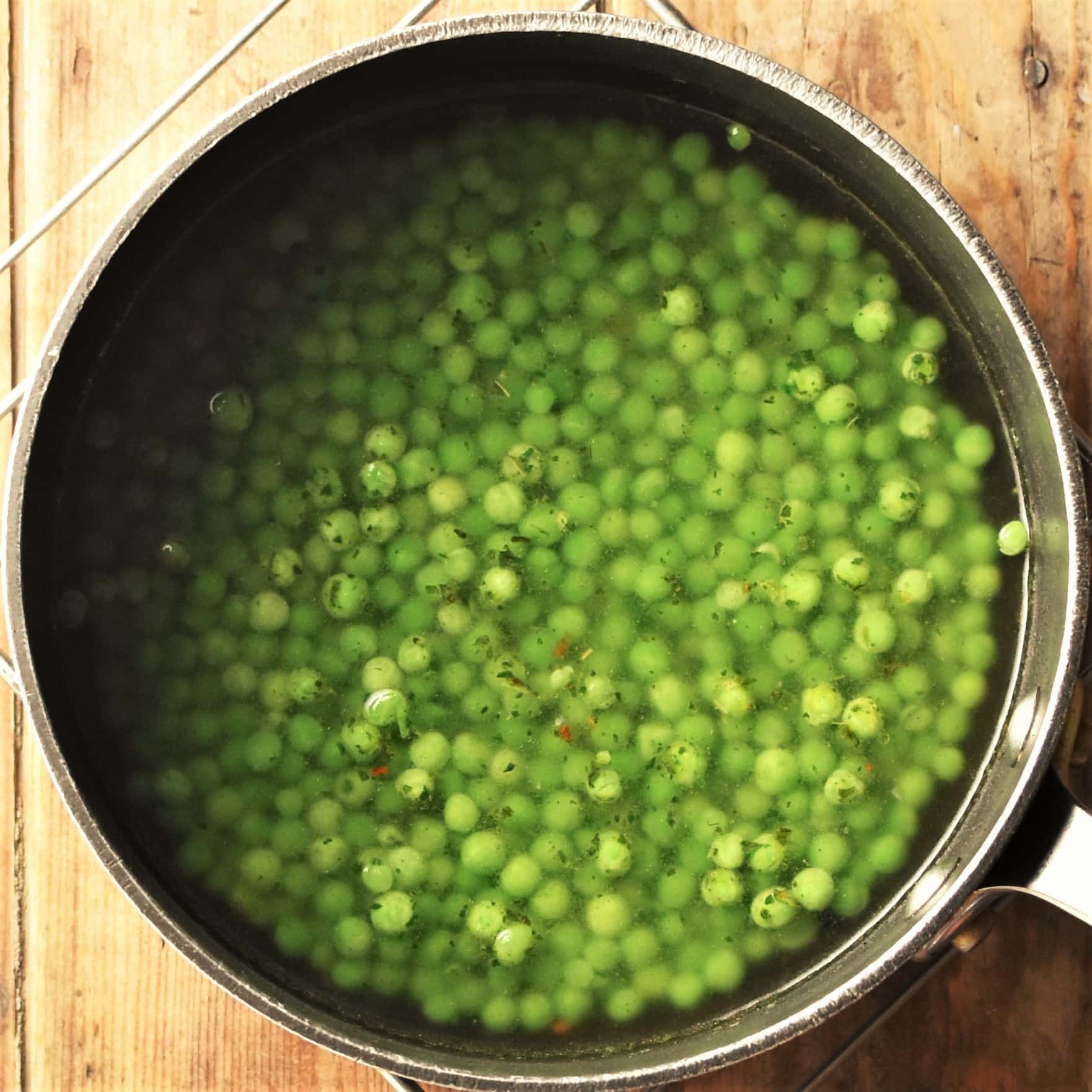 Peas with stock in pot.