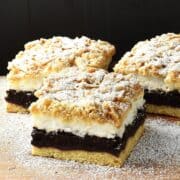 Side view of 3 plesniak cake slices on top of wooden surface.