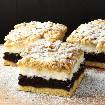 Side view of 3 plesniak cake slices on top of wooden surface.