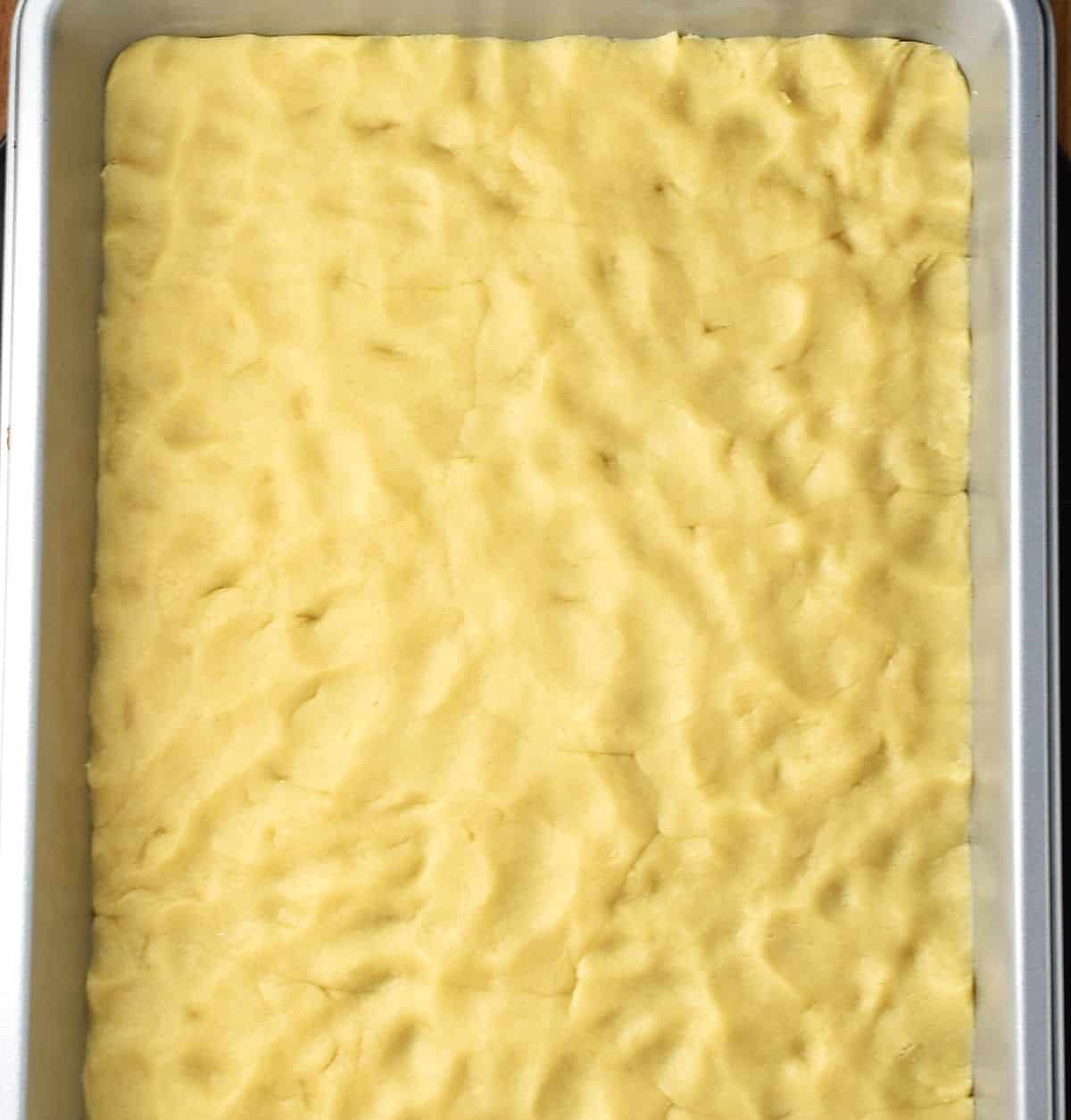 Top down view of dough spread over bottom of rectangular pan.