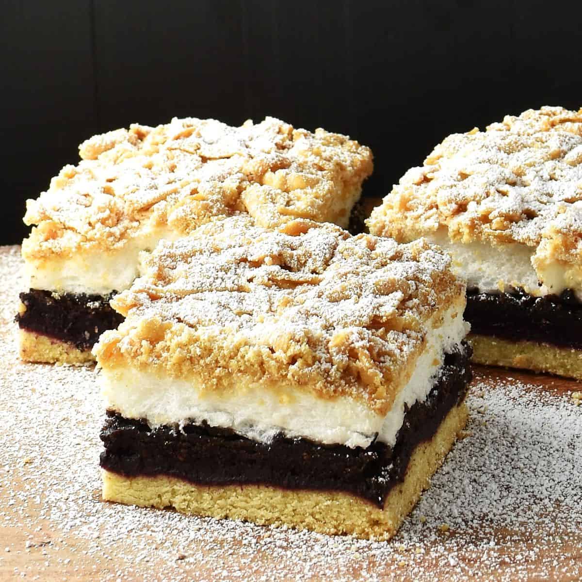 Side view of 3 plesniak cake slices on top of wooden surface.