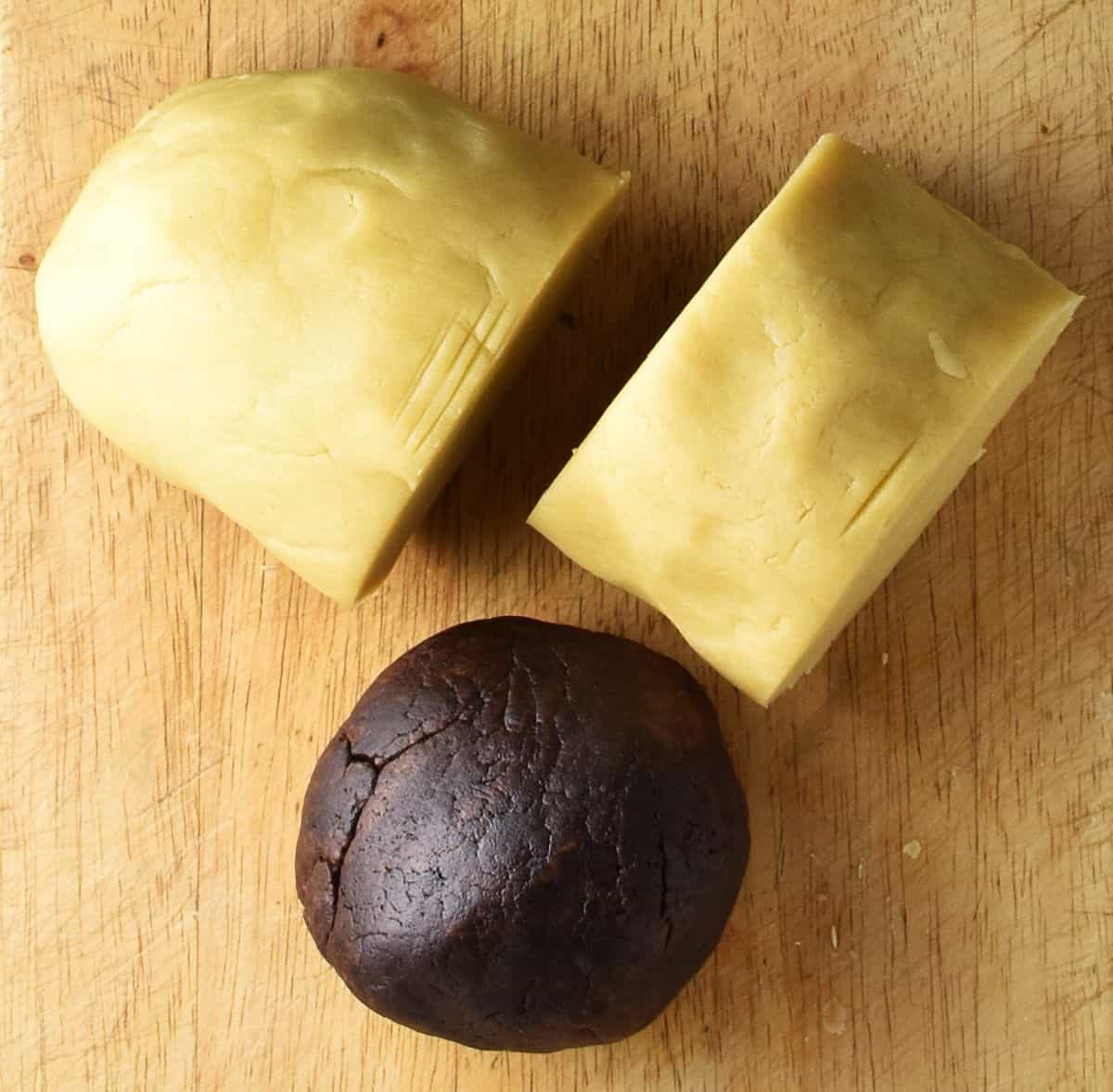 Top down view of 3 dough parts on top of cutting board.