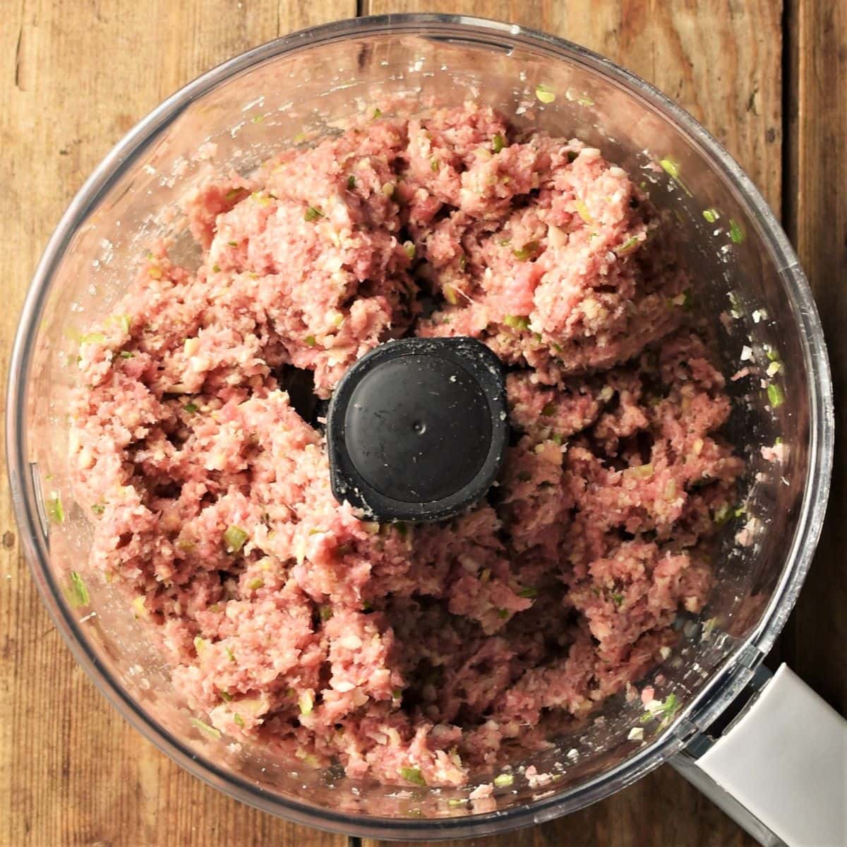 Meatballs mixture in food processor bowl.