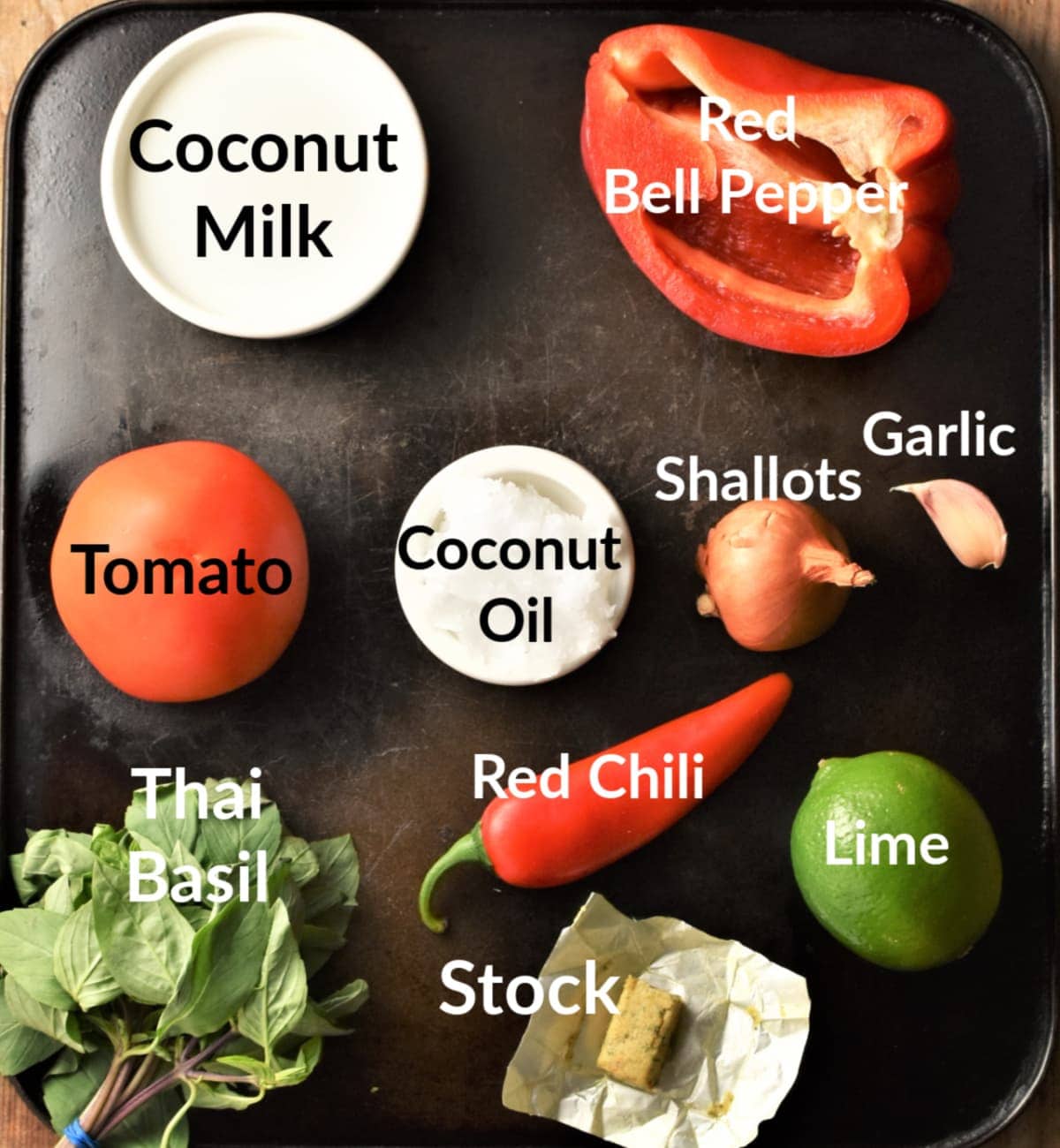 Ingredients for shrimp in coconut sauce on top of black tray.