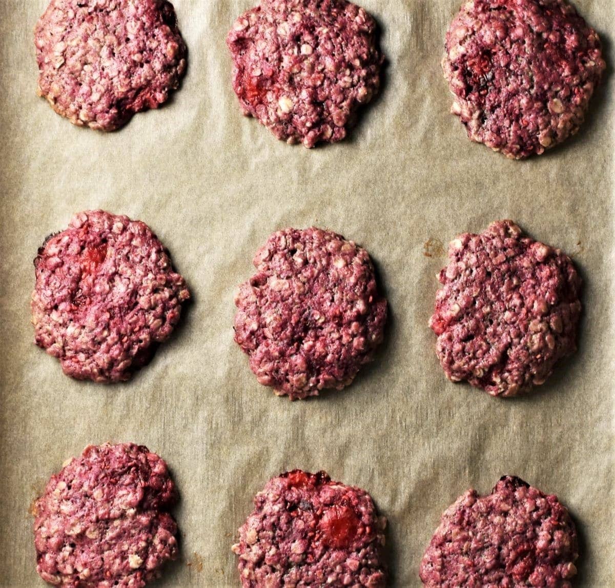 Baked raspberry cookies on top of parchment.