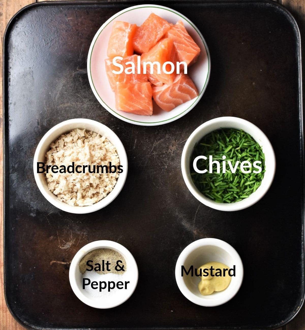 Ingredients for making fresh salmon burgers in individual dishes.