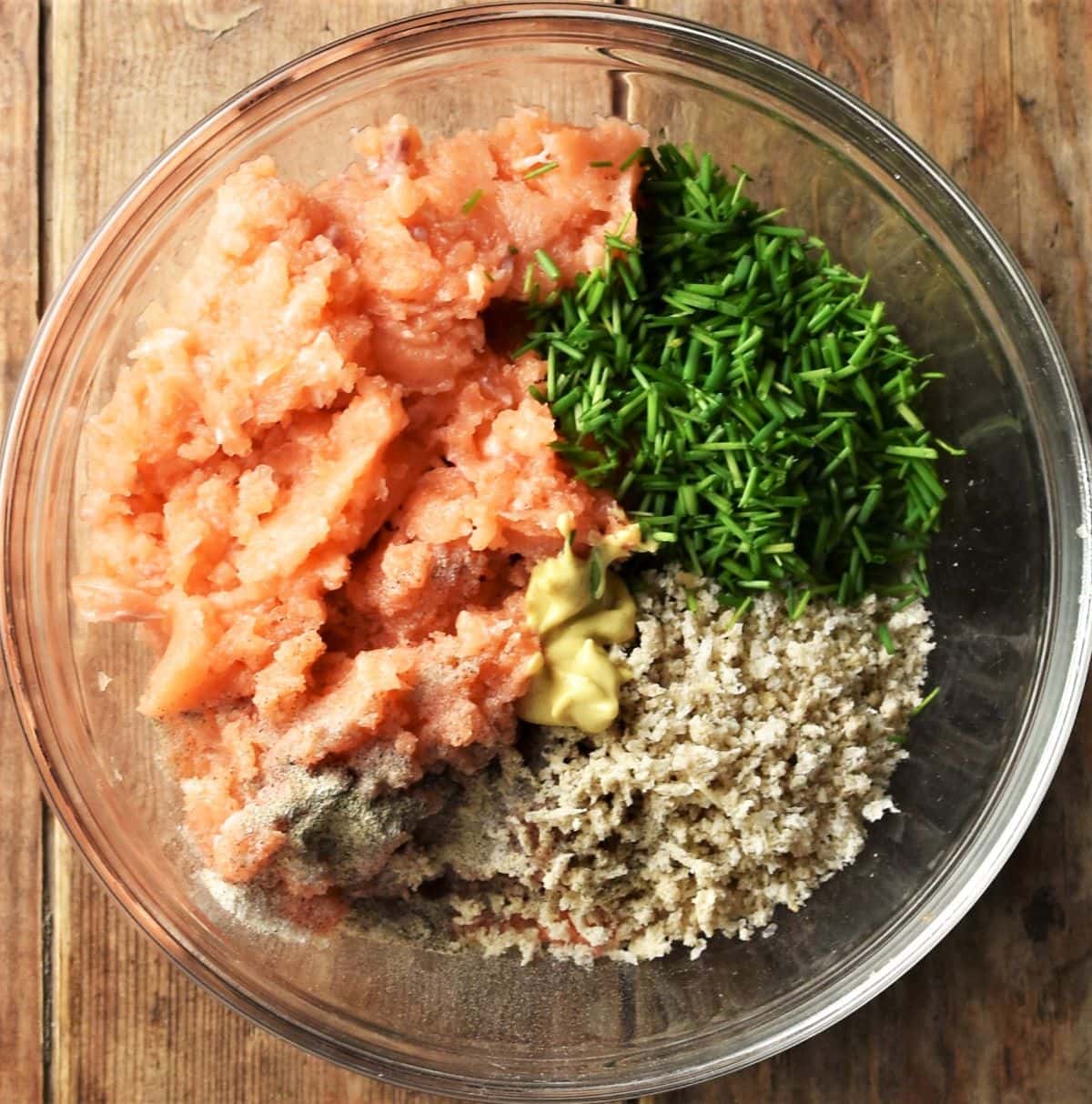 Salmon, breadcrumbs, chopped chives and seasoning in mixing bowl.