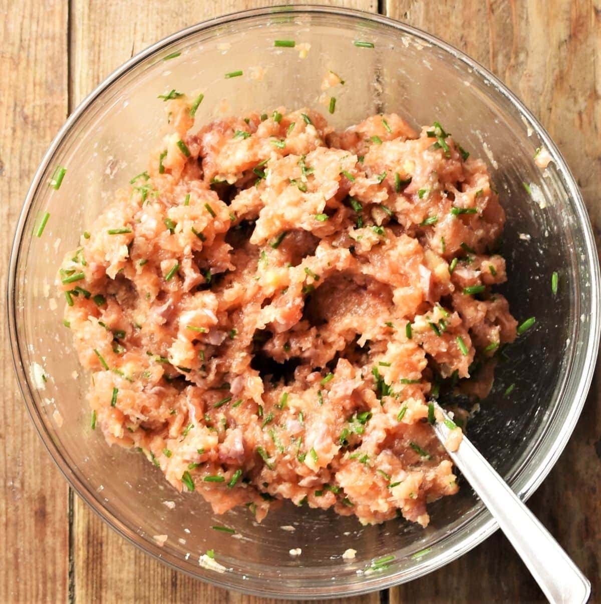 Salmon burger mixture in bowl with spoon.