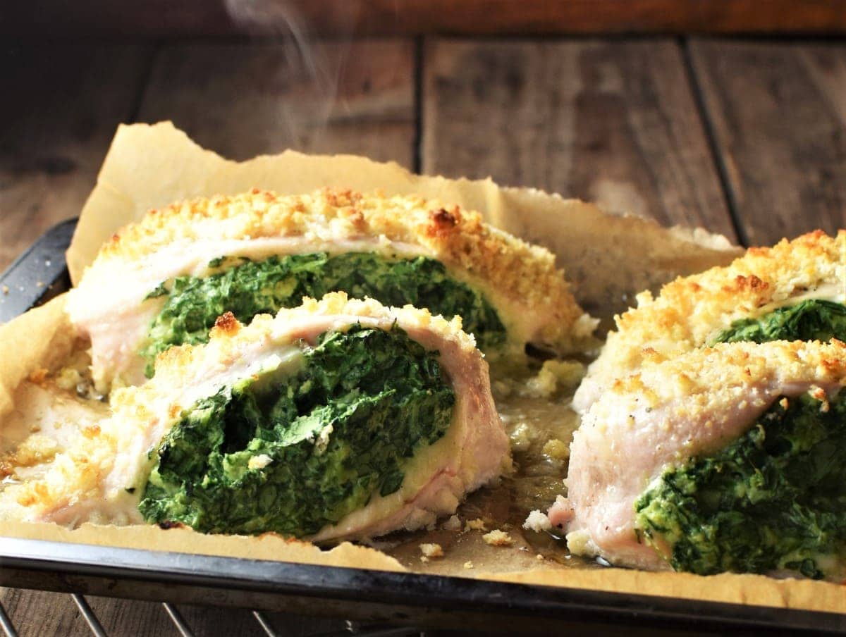 Side view of spinach stuffed chicken breasts with breadcrumb topping.