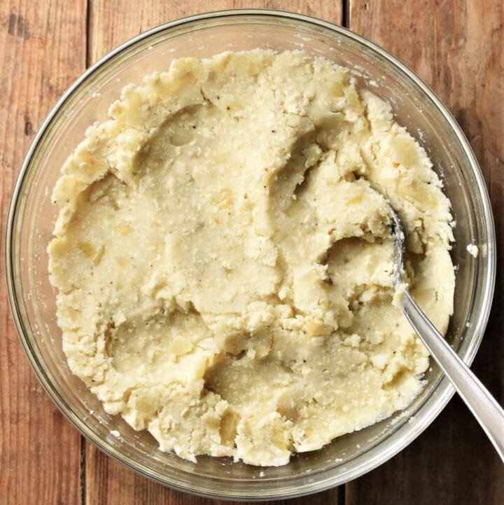 Vegan pierogi filling in mixing bowl with spoon.