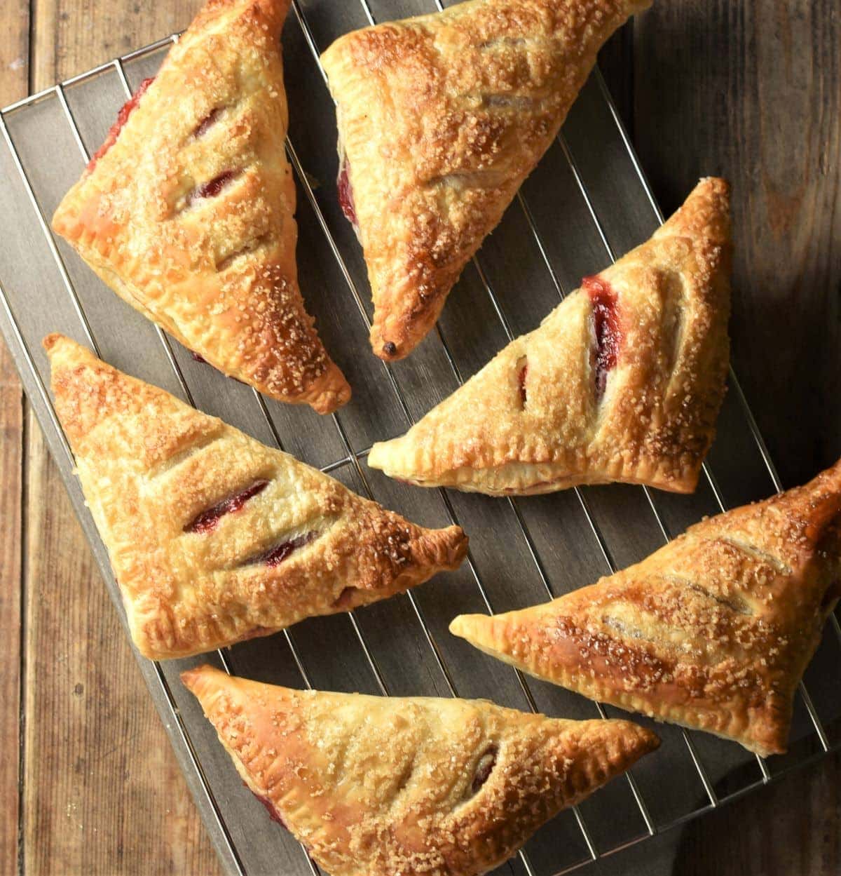 6 baked strawberry turnovers on top of cooking rack.