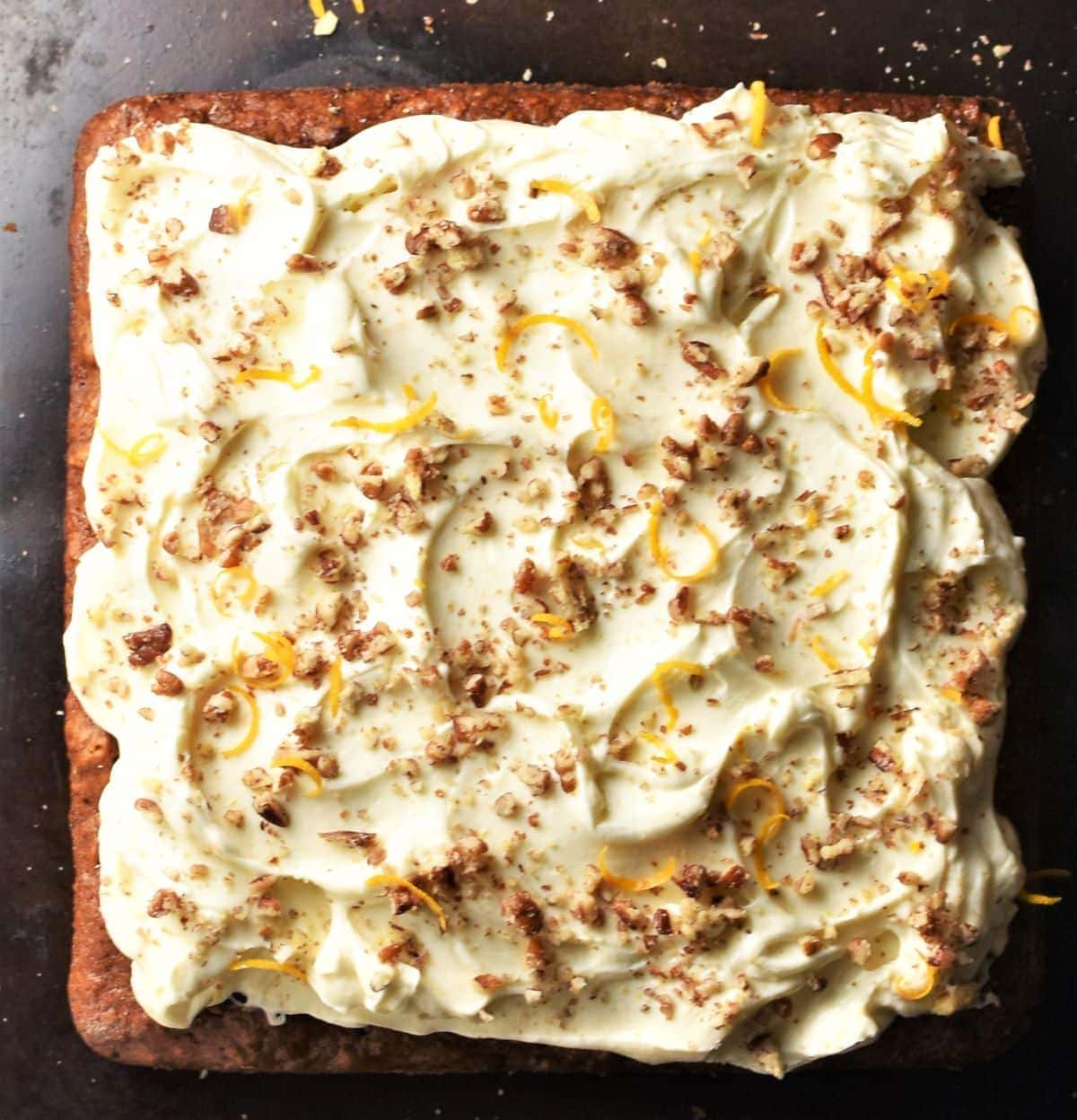 Carrot cake with cheese frosting and crushed pecans.