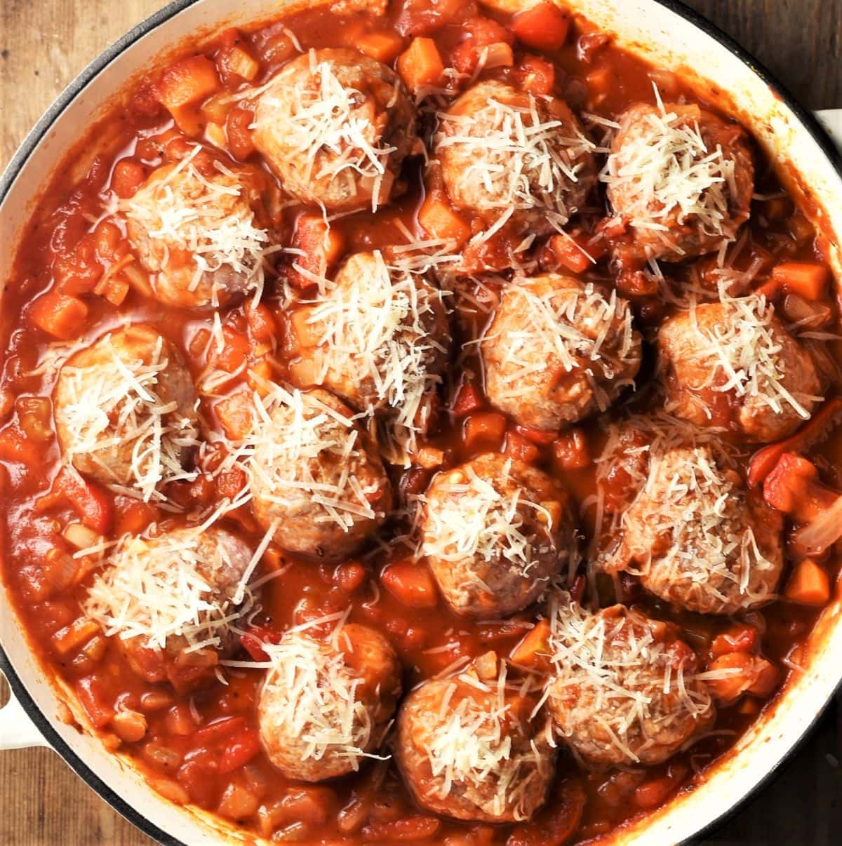 Top down view of meatballs in chunky vegetable sauce.