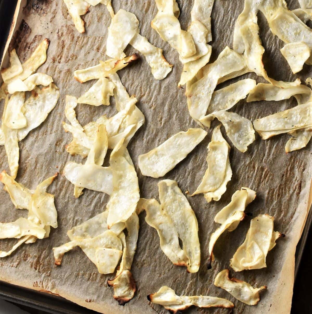 Roasted celery root shavings on top of parchment.