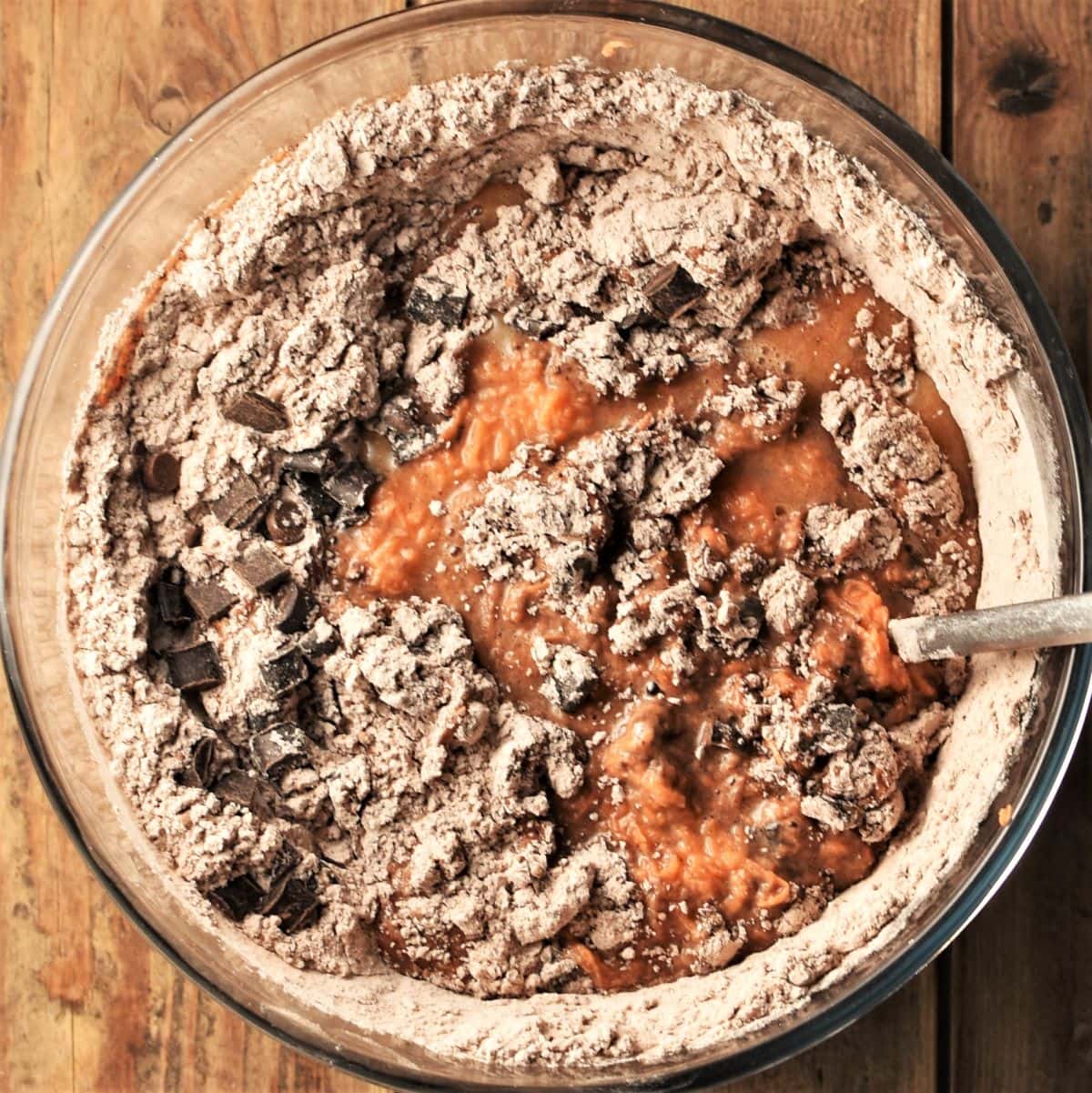 Sweet potato muffin batter in mixing bowl with spoon.