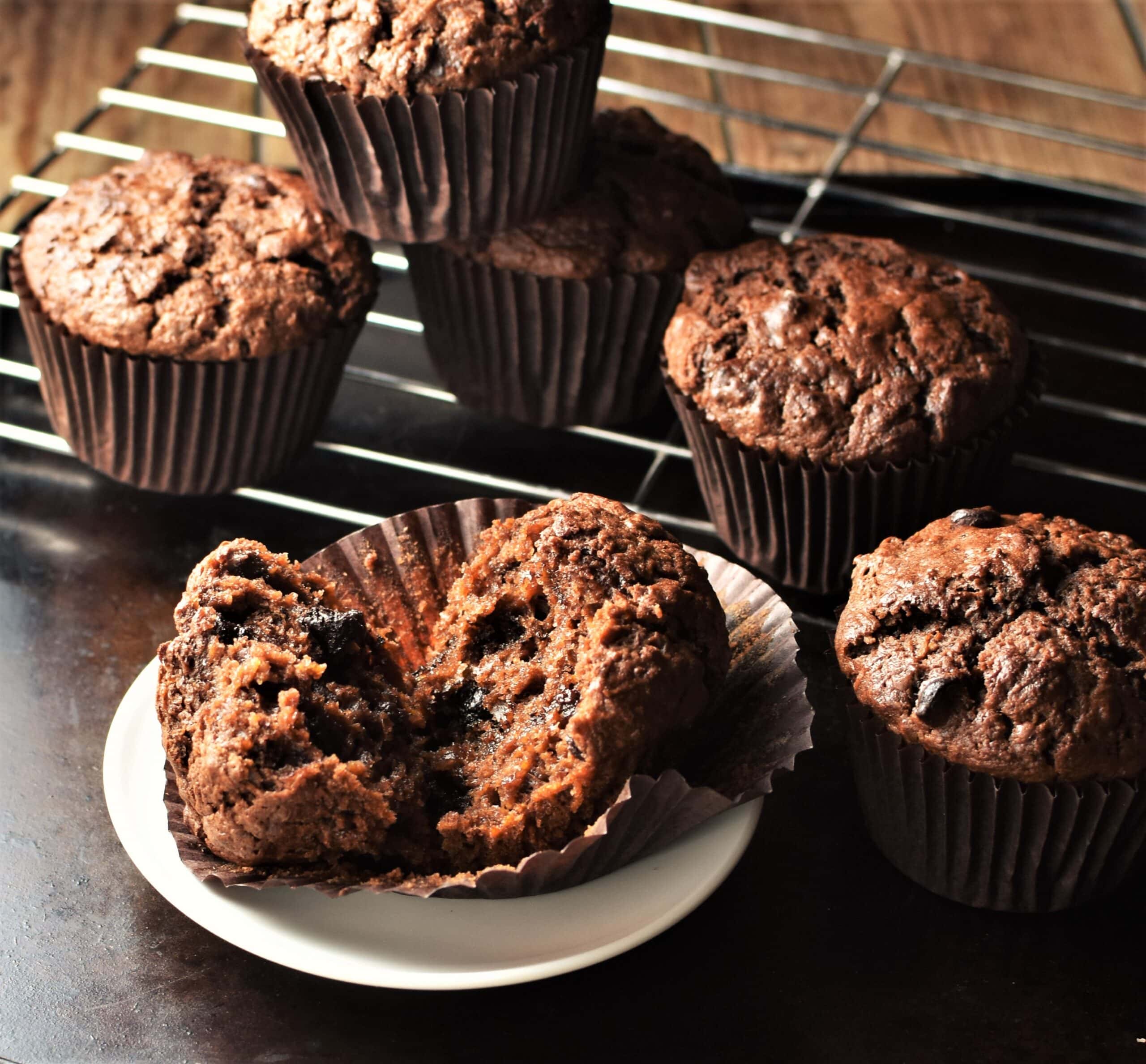 Side view of sweet potato chocolate muffins on white saucer and rack.