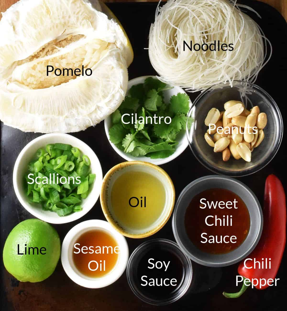 Top down view of pomelo salad ingredients in small individual dishes.