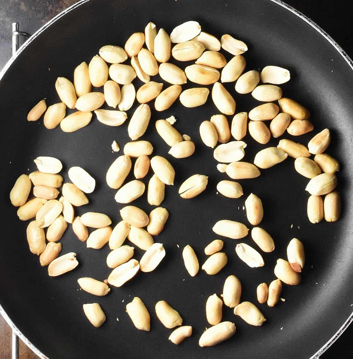 Toasting peanuts in large pan.