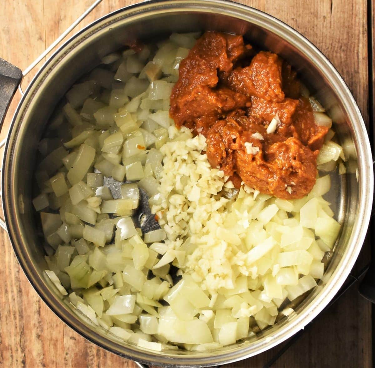 Chopped onion and curry paste in saucepan.