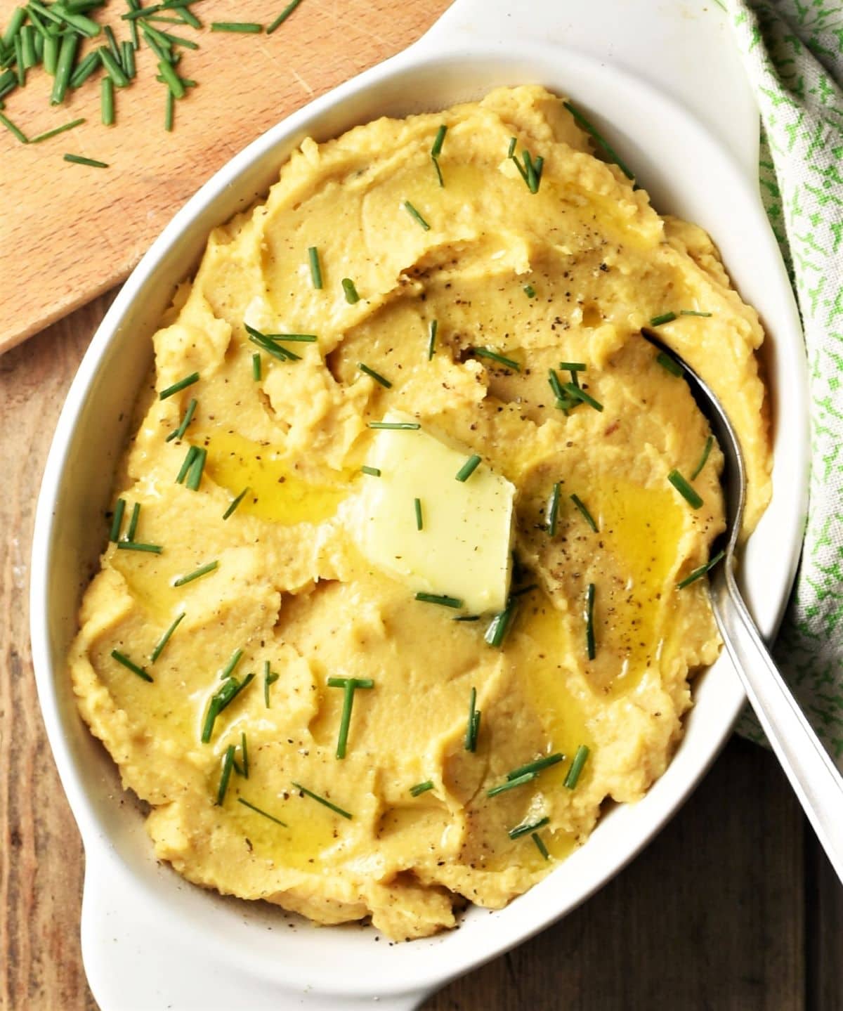 Mashed swede in white oval dish with spoon.