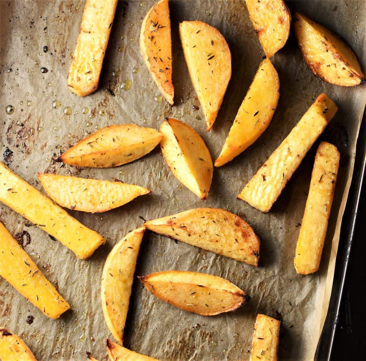 Roasted rutabaga wedges on top of parchment.