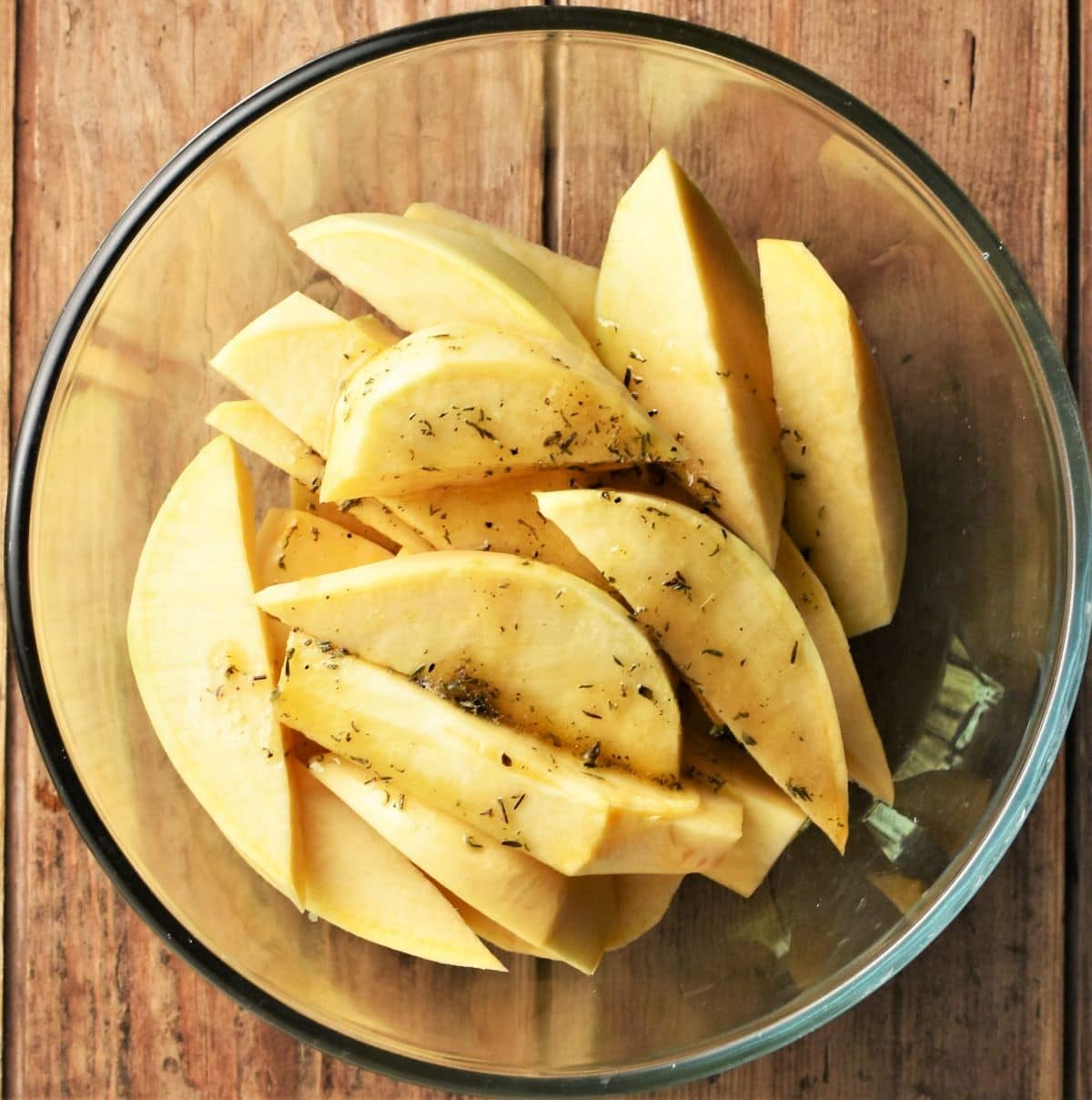 Swede wedges with herbs in mixing bowl.