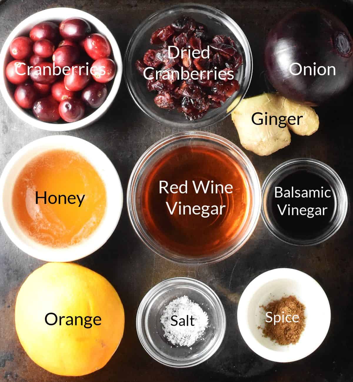 Ingredients for making festive cranberry chutney in individual dishes with labels.