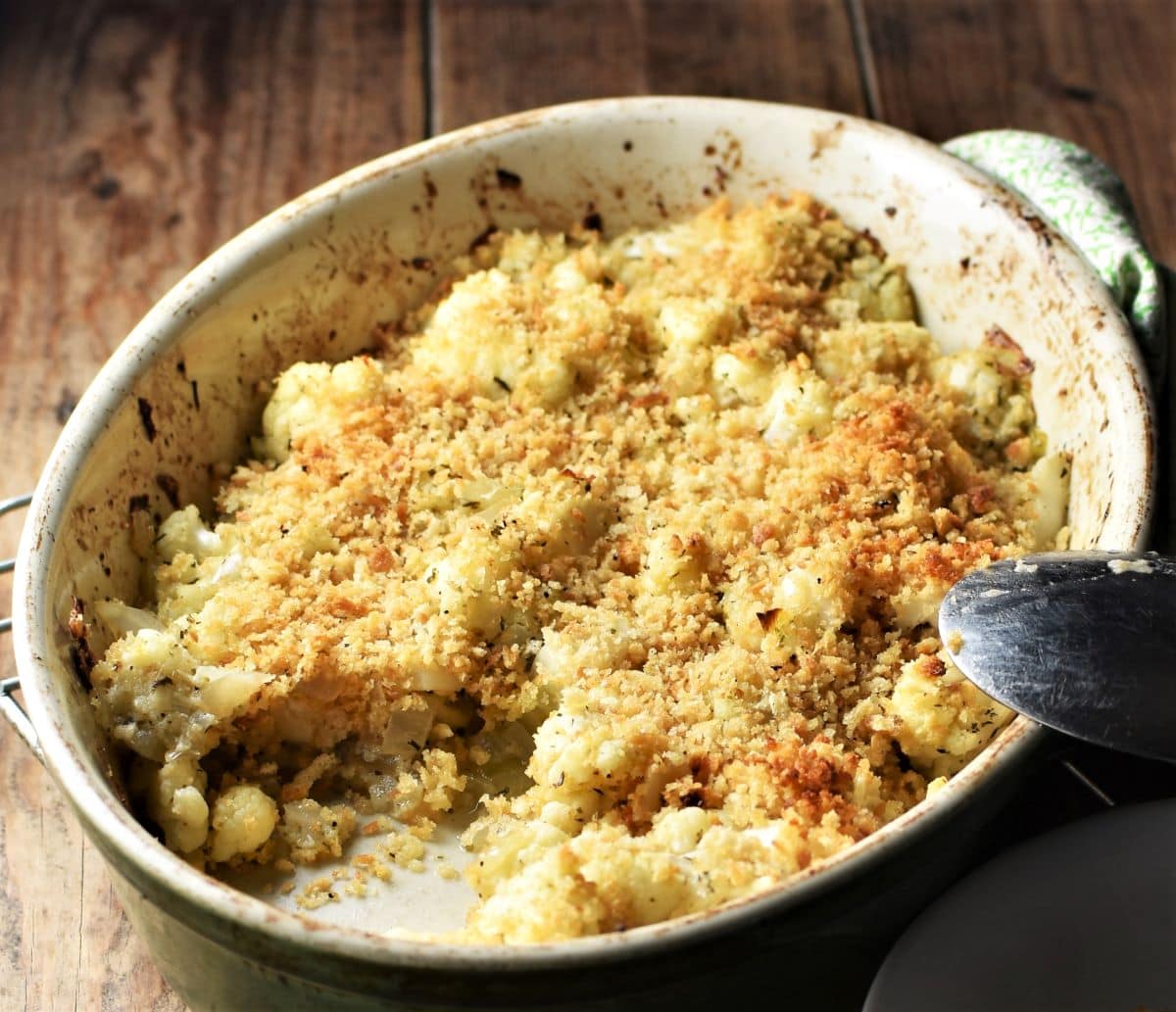 Side view of cauliflower stuffing with crispy breadcrumb topping in oval dish.