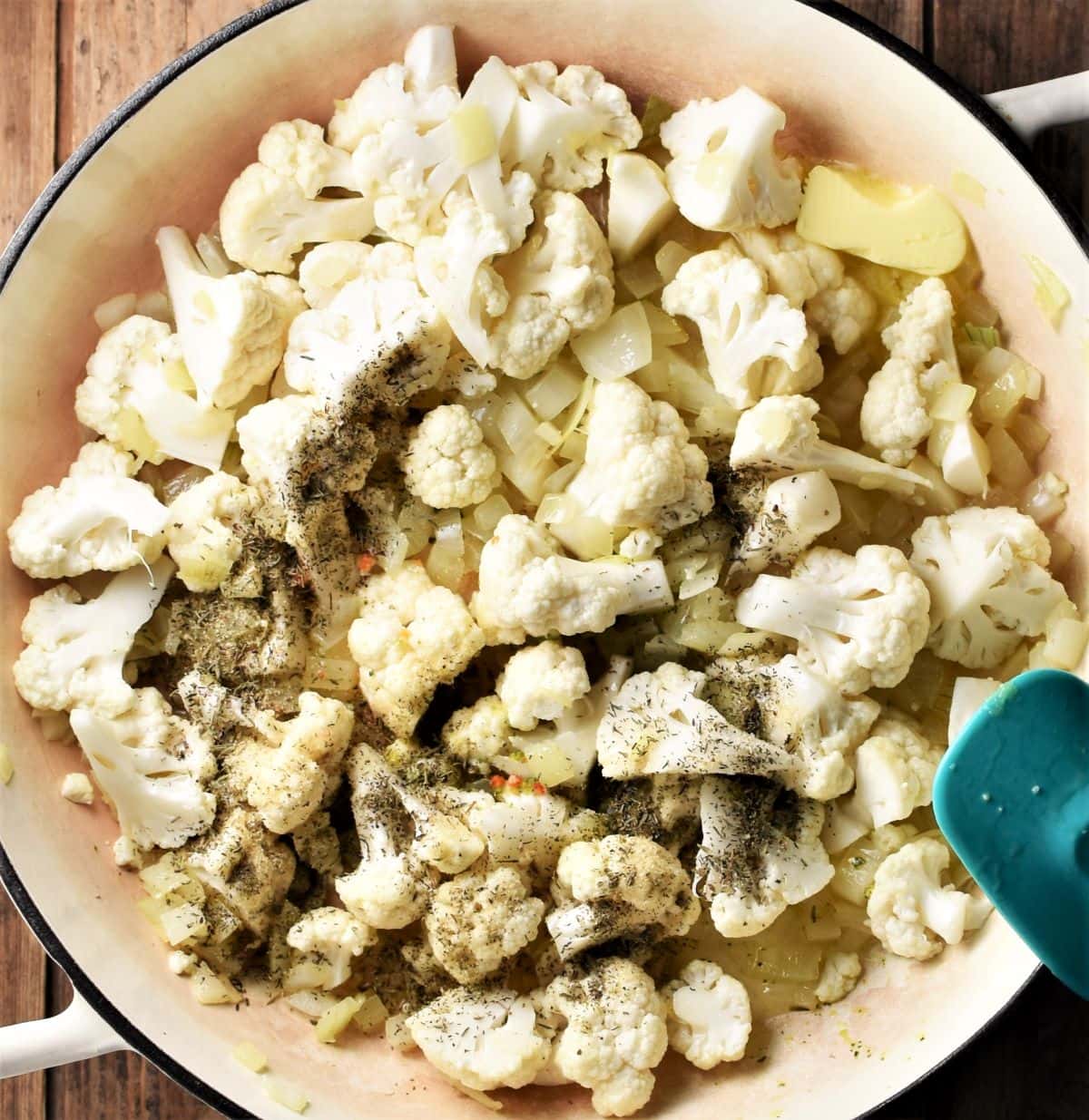 Making cauliflower stuffing mixture in large white pan.