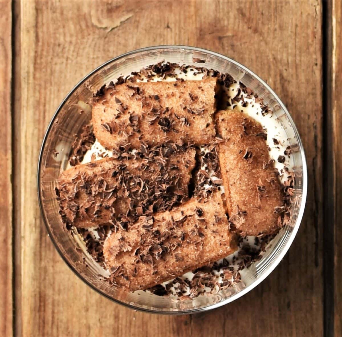 Layers or cream and ladyfingers with chocolate shavings in cup.