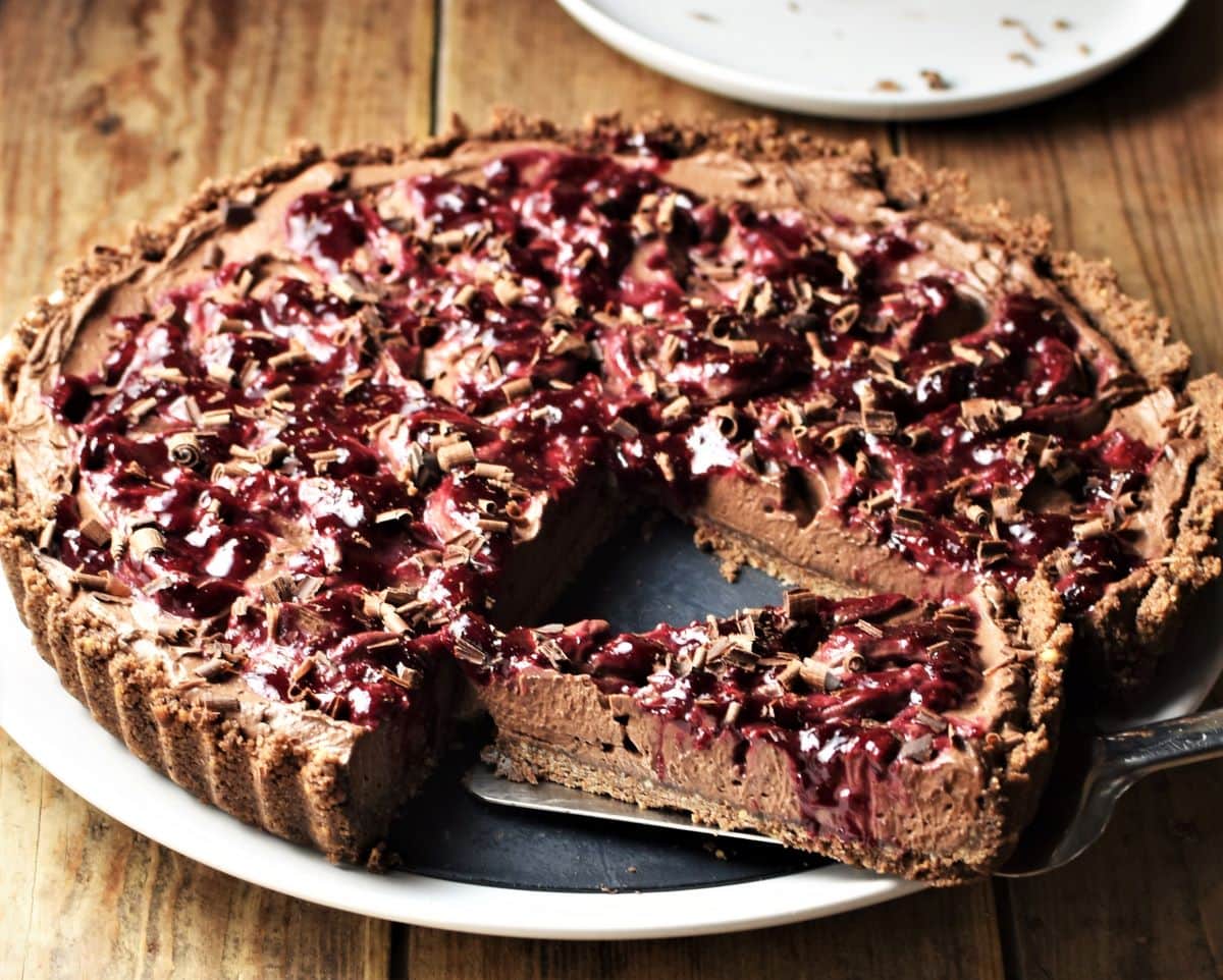 Side view of chocolate tart with cherry mixture topping.