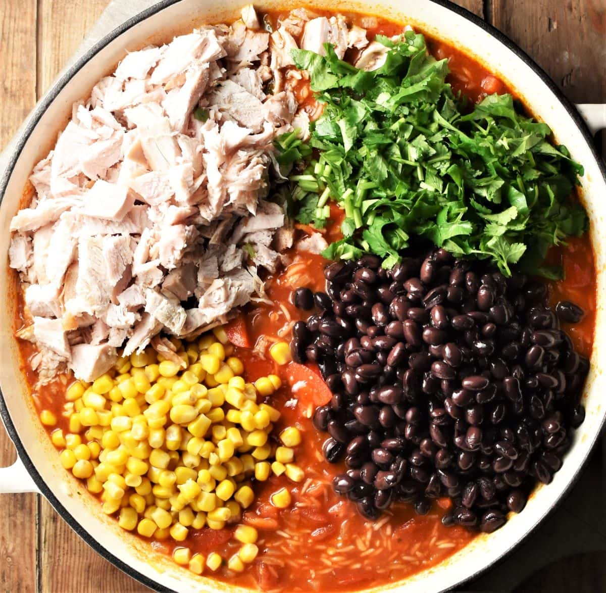 Chopped turkey, black beans, corn, herbs and tomato mixture in large pan.