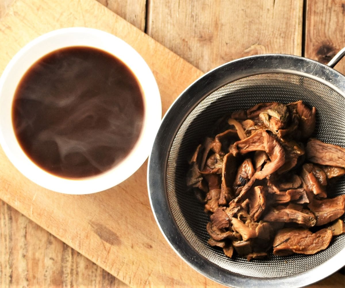 Mushroom broth and cooked mushrooms in sieve.