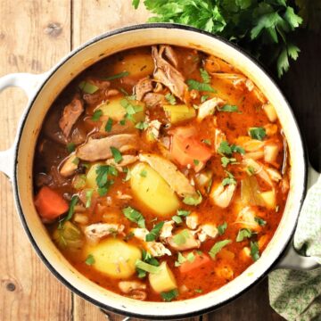 Winter stew with chicken, vegetables and herbs in pot.