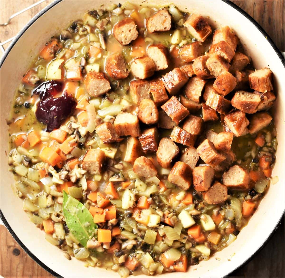 Making sausage pie filling with diced veggies in large pan.