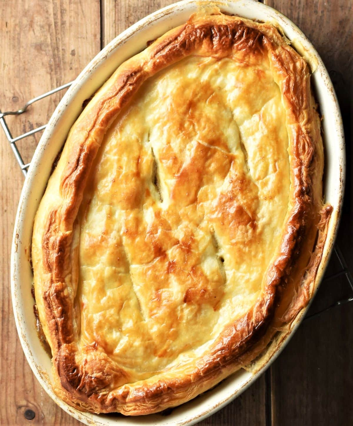 Top down view of pie with golden brown pastry in oval dish.