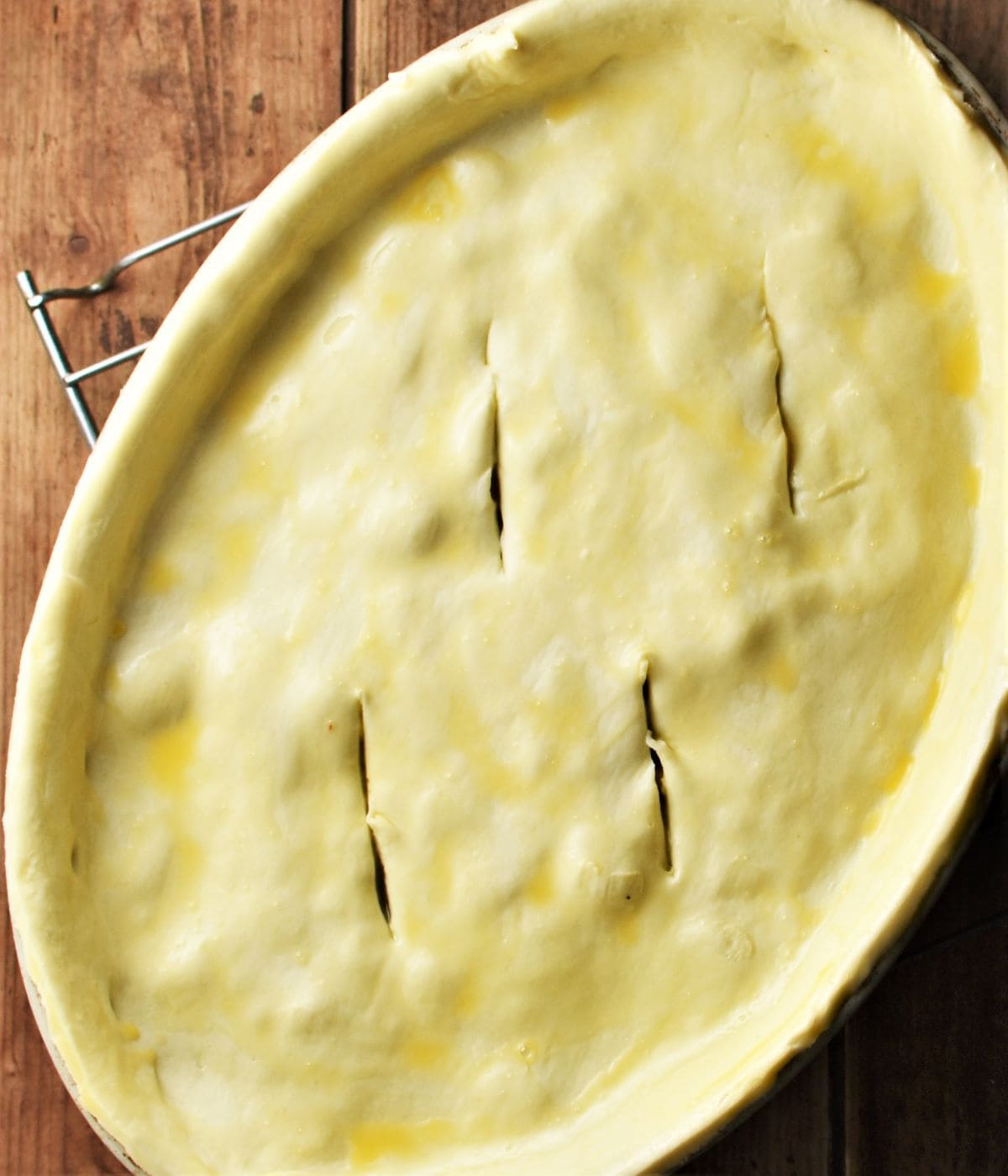 Pie with pastry on top in oval dish.