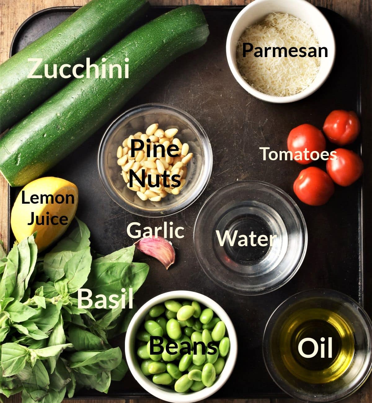 Ingredients for making pesto zoodles salad in individual dishes.