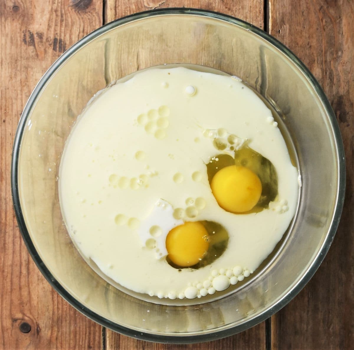 2 eggs and milk muffin mixture in bowl.