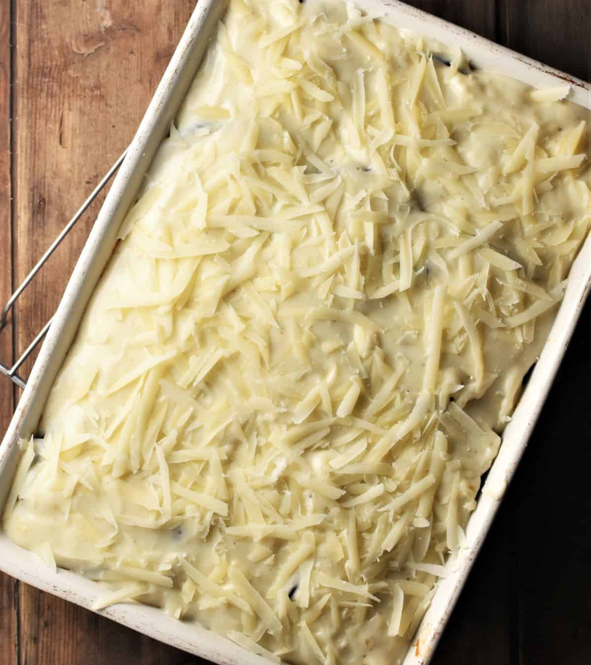 Top down view of moussaka with bechamel sauce and grated cheese on top.