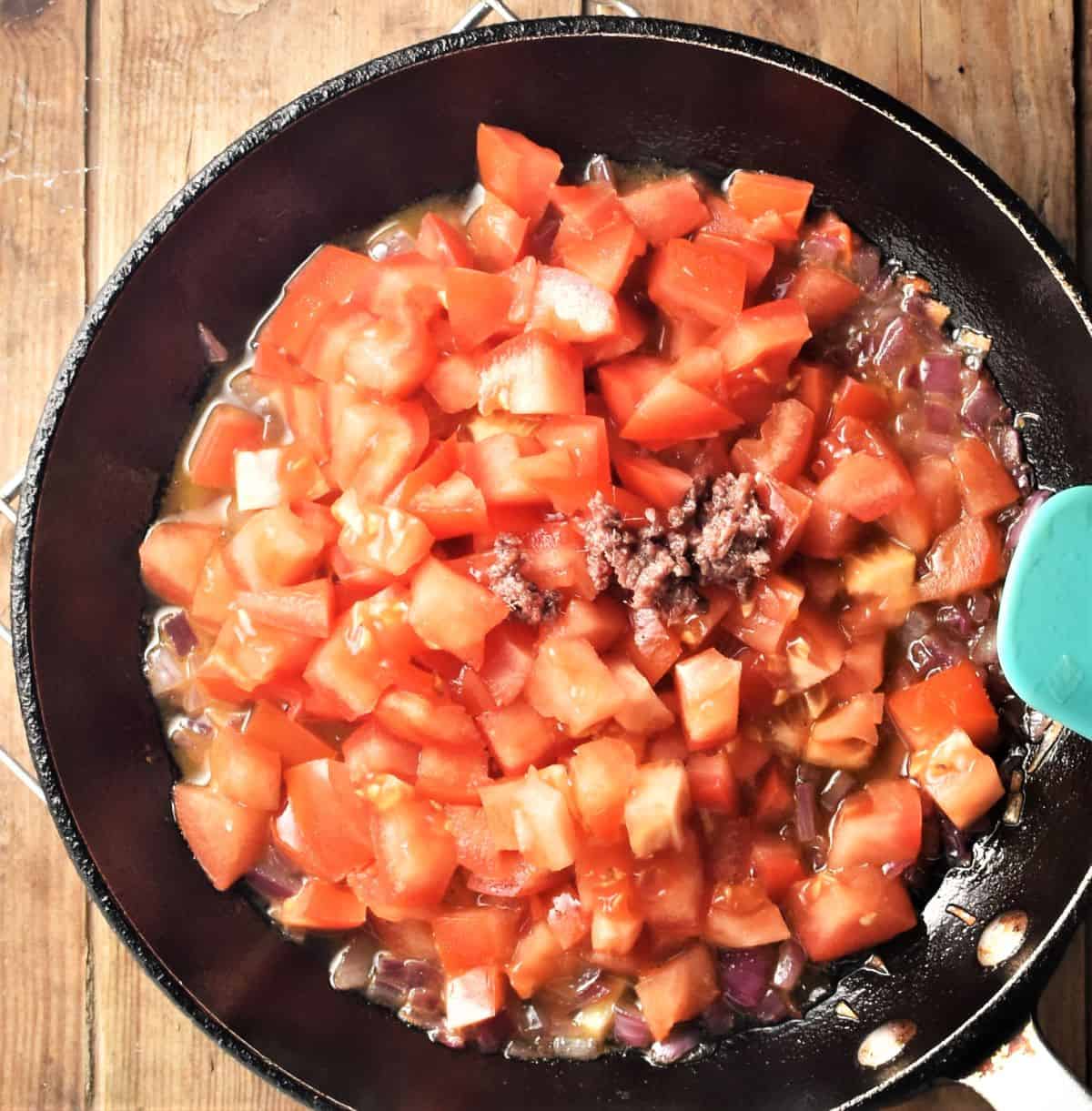 Making chunky tomato sauce in pan.