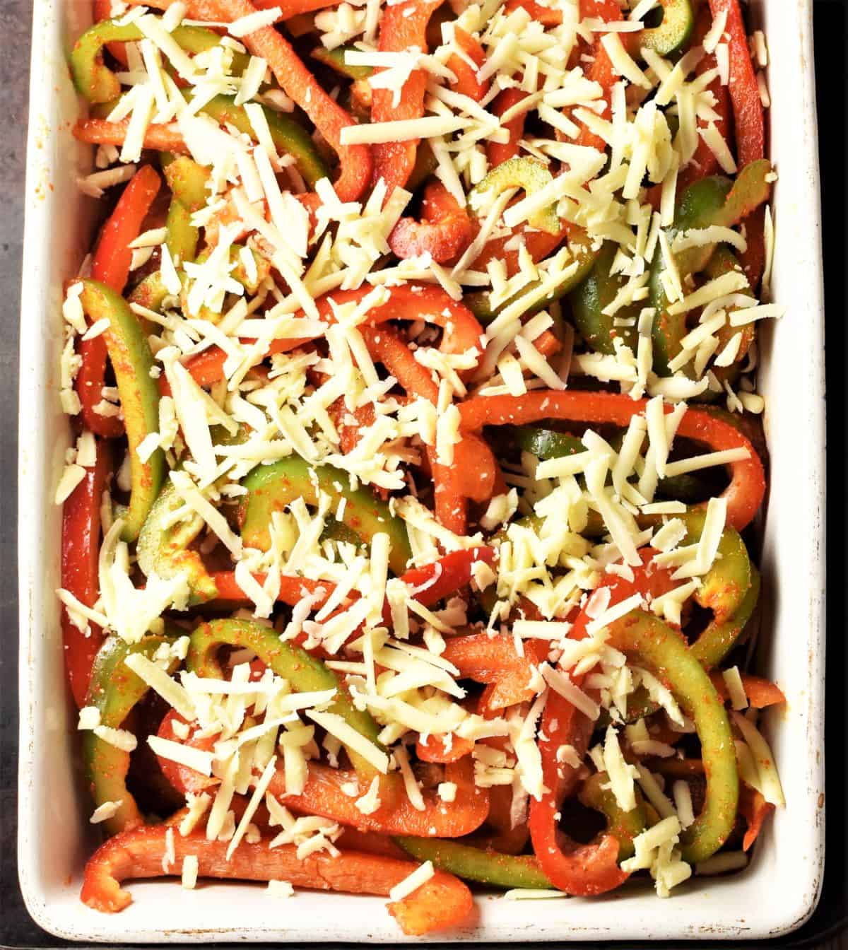 Top down view of unbaked casserole with peppers and cheese.