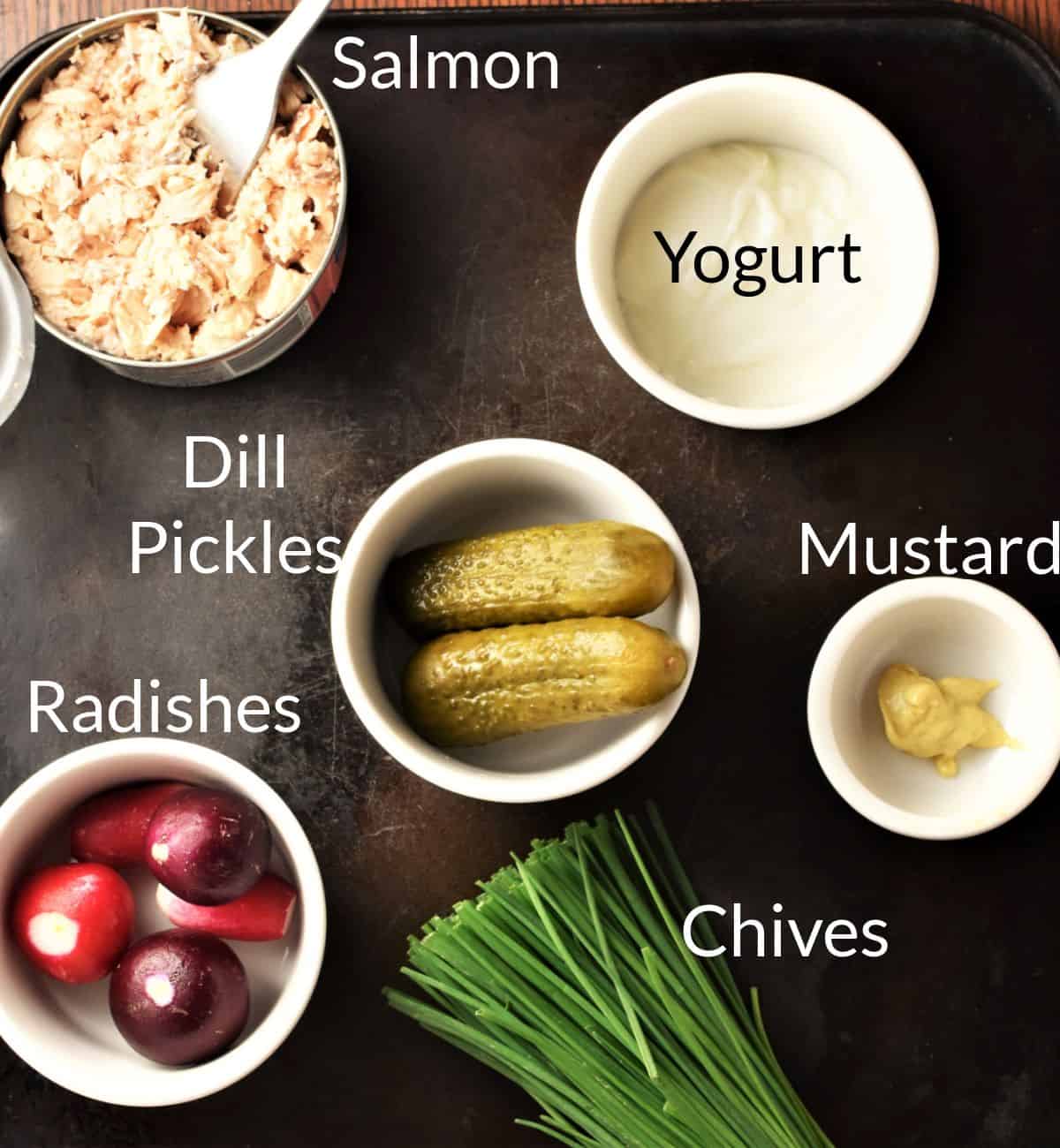 Ingredients for making salmon salad sandwich in individual dishes.
