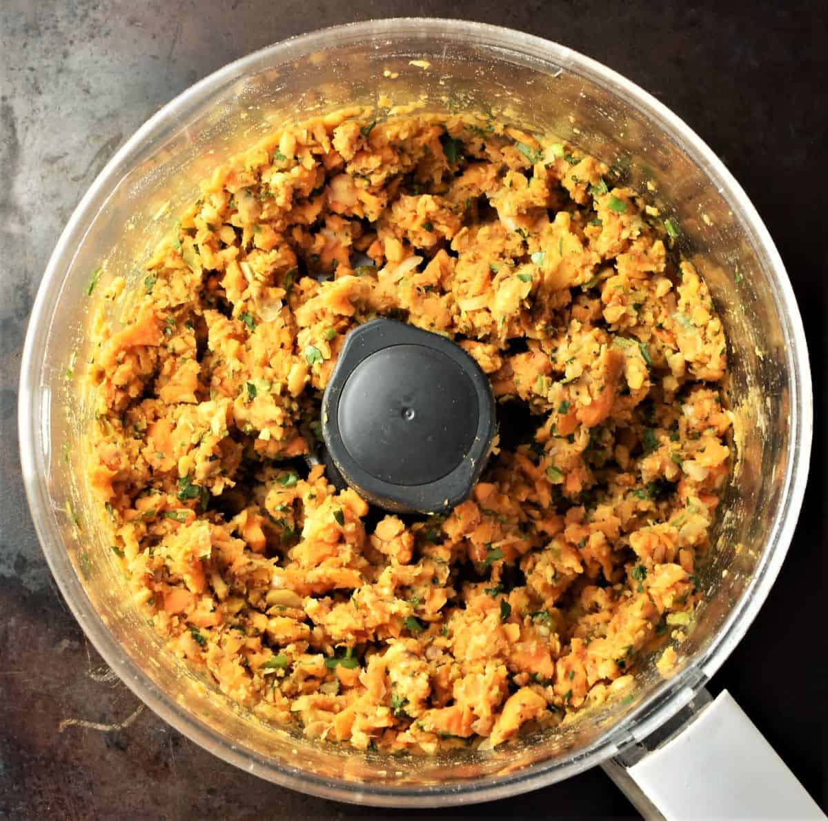 Chunky sweet potato burger mixture in blender bowl.