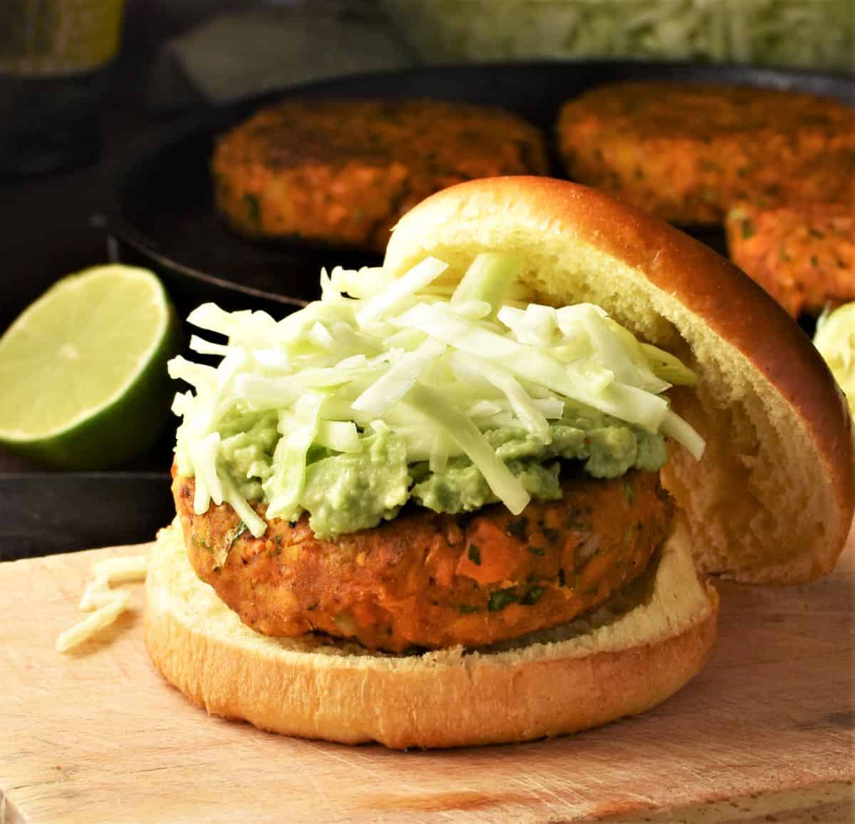 Side view of veggie burger in brioche bun with shredded cabbage.