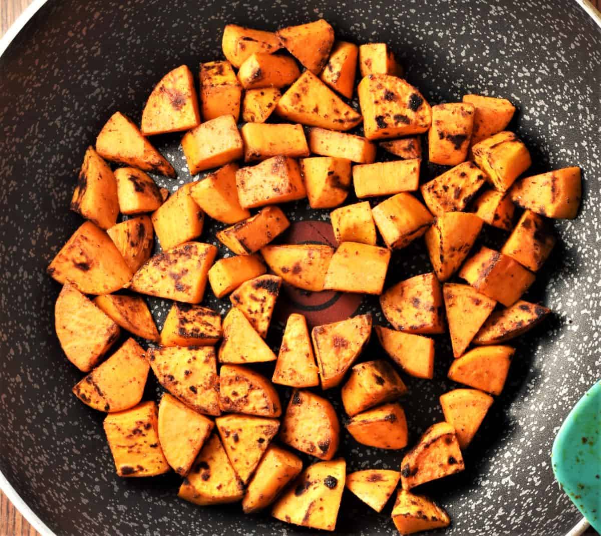 Frying sweet potato chunks in large pan.