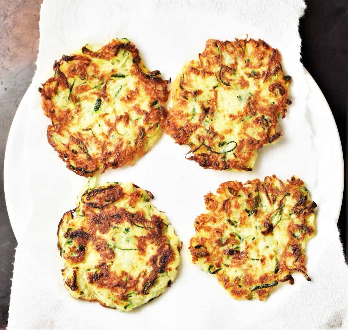 4 fritters on top of plate lined with paper towel.